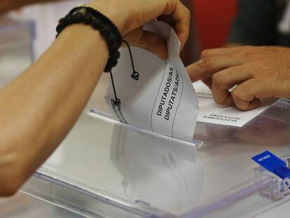 Una persona deposita su voto en una urna montada en Barcelona.