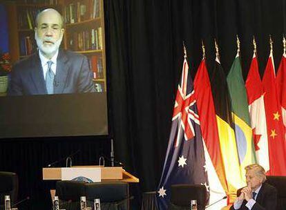 Trichet escucha a Bernanke durante una videoconferencia en el encuentro de Barcelona.