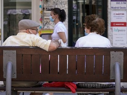 Una pareja de ancianos con mascarilla sentada en un banco de Madrid el pasado julio.