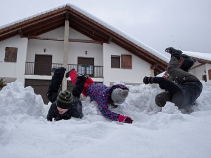 Tres niños se divierten en la nieve caída en Espinal (Navarra).