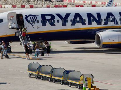 Varios viajeros, en imagen de archivo, desembarcan de un avión de Ryanair en el aeropuerto de Girona.