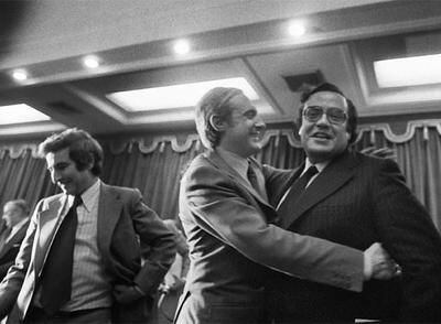Pérez-Llorca (centro) abraza a Peces-Barba, en presencia de  Cisneros, tras la última sesión de la Comisión Constitucional del Congreso, que aprobó el dictamen de la Constitución el 20 de junio de 1978.
