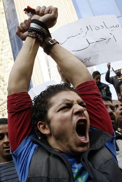 Manifestantes enarbolan una pancarta en la que puede leerse "váyase, presidente", en El Cairo.