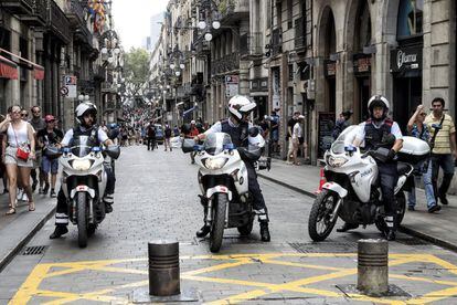 Tres Mossos d'Esquadra motorizados permanecen en la calle de Ferran, entre la plaza de St. Jaume y la Rambla, en Barcelona.