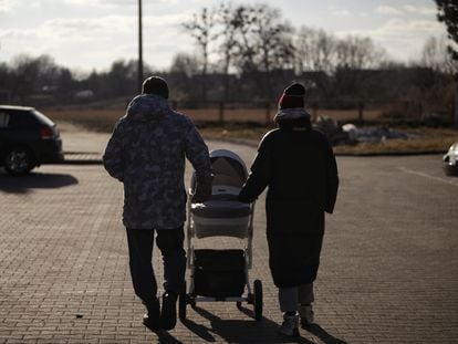 Alex y Maria, con el carrito de su bebé, el jueves frente al centro de acogida de refugiados en Hrubieszow (Polonia).