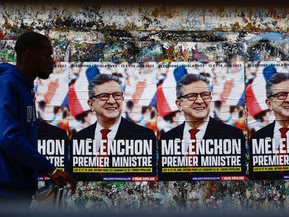 Un hombre pasa por delante de unos carteles del candidato de La Francia Insumisa, Jean-Luc Mélenchon, en una calle de Paris.