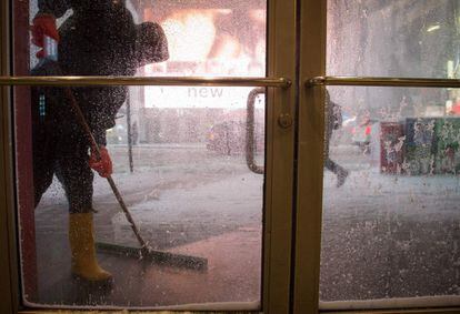 Un trabajador quita la nieve de la entrada del metro de Times Square, en  Nueva York.
