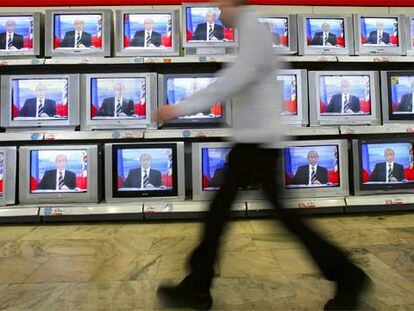 Un hombre camina en Moscú por delante de un escaparate con televisores que muestran la imagen del presidente Vladímir Putin.