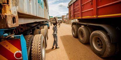 Un niño se busca la vida vendiendo agua mineral a los camioneros que esperan en la cola.