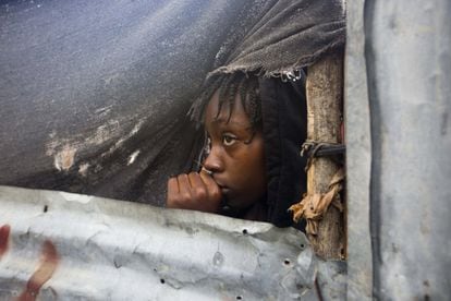 Una nena observa les autoritats evacuar a la població, la majoria dels 11 milions d'haitians habiten en habitatges fràgils.