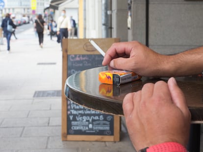 Una persona fuma en una terraza durante el primer día de la prohibición en Galicia.