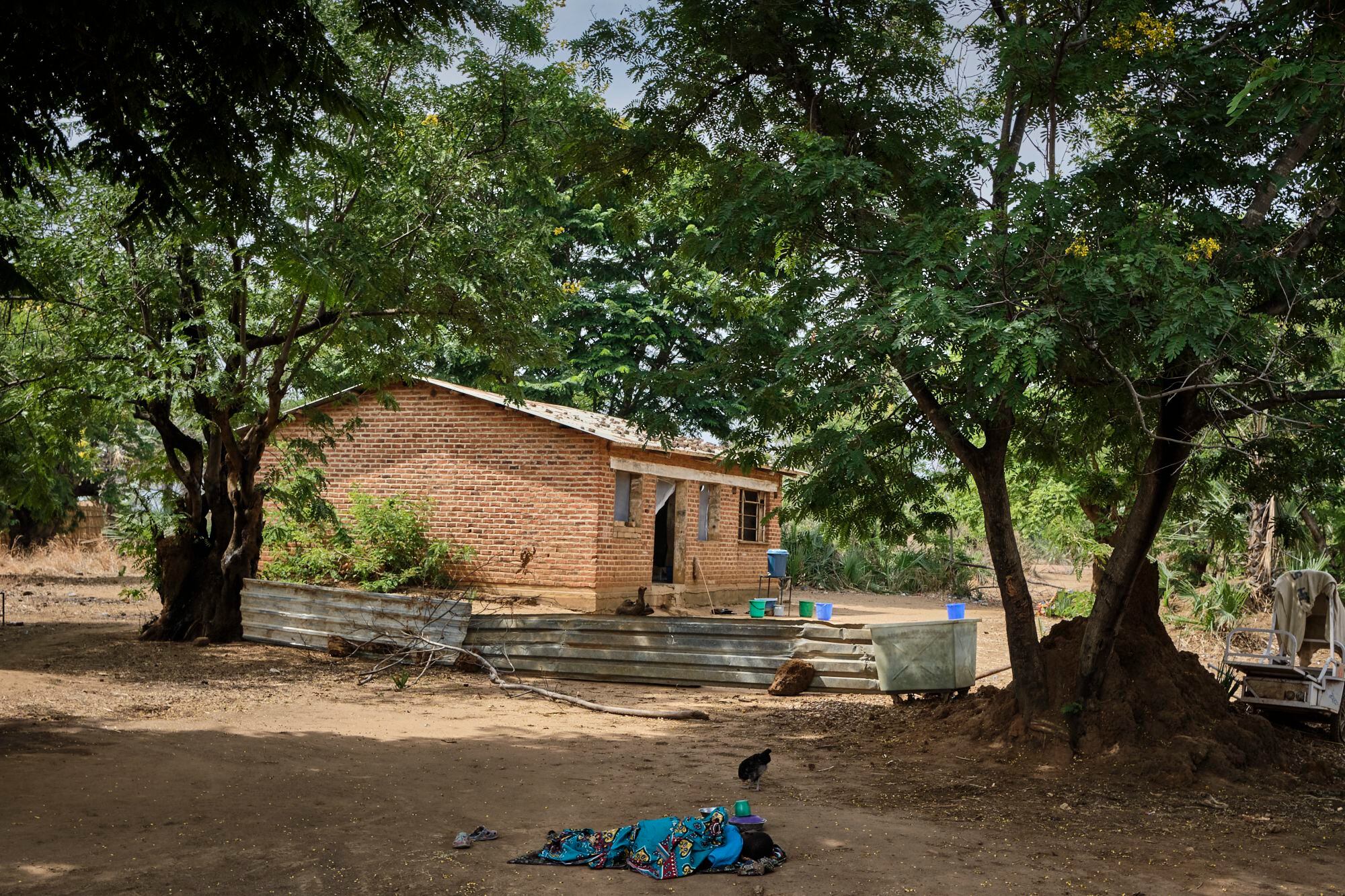 Una niña enferma de cólera descansa cerca del centro de salud de Mtosa, en el distrito de Nkhotakota, Malaui. Este distrito es el que más muertes por cólera ha registrado desde el inicio del brote en marzo de 2022. Hasta ahora, se han detectado 1.044 casos y 47 muertes. Al fondo, el edificio improvisado para los pacientes enfermos de cólera.