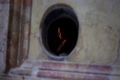 Una mujer reza dentro la tumba de Jesucristo en la basílica del Santo Sepulcro en Jerusalén, Israel.