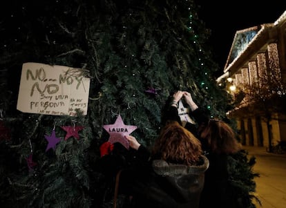 Dos mujeres colocan en un árbol de Navidad de la Plaza del Castillo en Pamplona dos estrellas, una de ellas con el nombre de Laura Luelmo y la otra con el numero de mujeres asesinadas este año.
