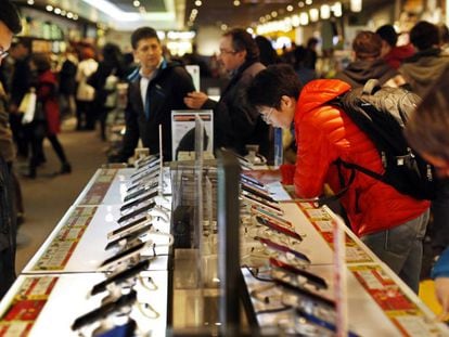 Varias personas miran móviles en una tienda Fnac de Madrid.