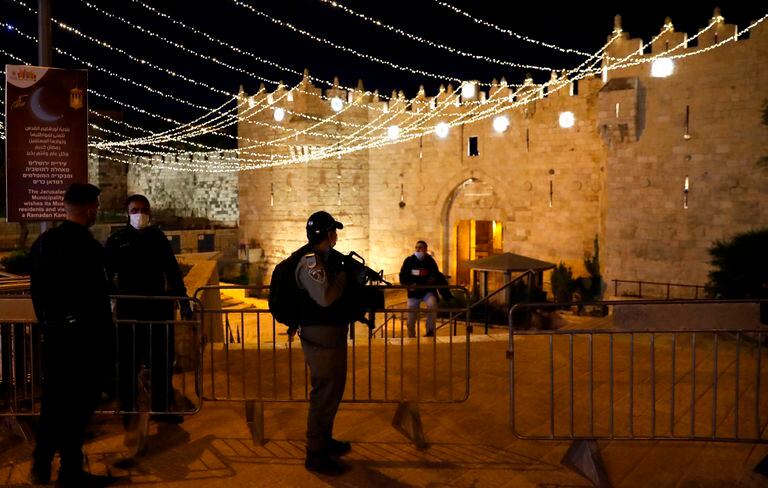 Policías israelíes ante la puerta de Damasco de Jerusalén, engalanada para el Ramadán.