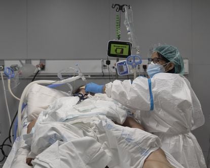 Un sanitario atiende a un paciente ingresado en la UCI del hospital Enfermera Isabel Zendal de Madrid, el pasado 13 de enero.