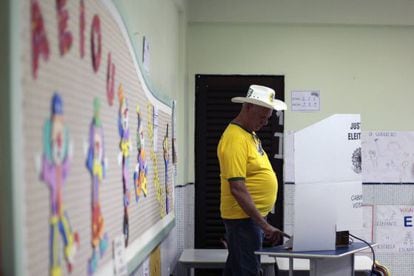 Un hombre con camisa amarilla vota en una escuela en Brasilia.
