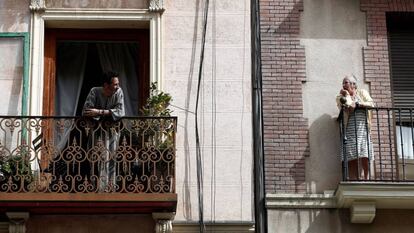 Dos vecinos conversan en el balcón de sus casas en Madrid.