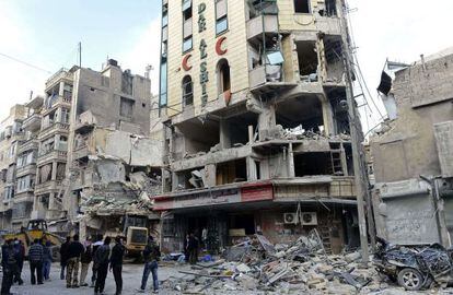 Rebeldes sirios y viandantes observan los trabajos de desescombro del hospital Dar al Shifa.