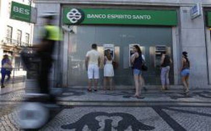 Gente que saca dinero de cajeros autom&aacute;ticos de una oficina de Esp&iacute;rito Santo en Lisboa. 