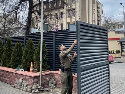 Un agente del Grupo Especial de Operaciones (GEO) de la Policía Nacional arría este viernes la bandera española de la embajada en Kiev, Ucrania.