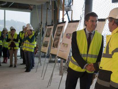 Feij&oacute;o, en el centro, saluda a un responsable de las obras del hospital de Vigo durante una visita.