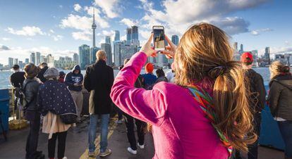 Turistas a bordo de un ferri frente al puerto de Toronto (Canadá).