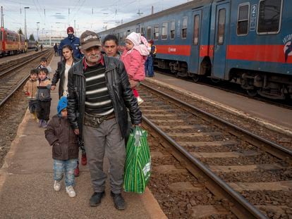 Refugees fleeing the war from neighboring Ukraine walk on a platform after disembarking from a train in Zahony, Hungary, Wednesday, March 2, 2022. At the train station in the Hungarian town of Zahony on Wednesday, more than 200 Ukrainians with disabilities — residents of two care homes in Ukraine's capital of Kyiv — disembarked into the cold wind of the train platform after an arduous escape from the violence gripping Ukraine. (AP Photo/Balazs Kaufmann)
