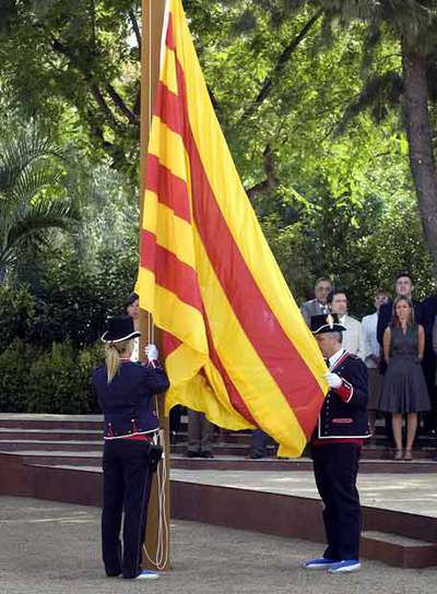 La bandera es izada por dos <i>mossos</i> durante la celebración.