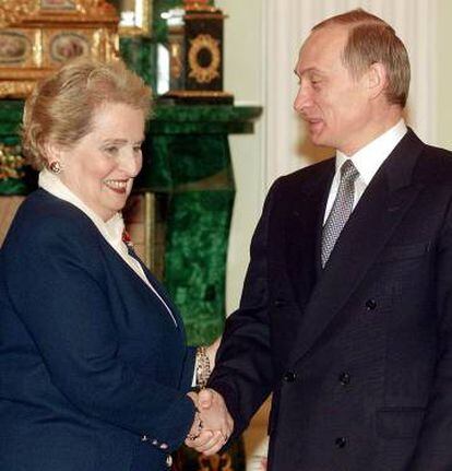 Madeleine Albright, junto a Vladimir Putin, quien le observa el hombro.