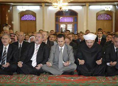 El presidente sirio, Bachar el Asad (centro), reza en la mezquita de Khaled bin al-Walid, en la ciudad siria de Homs.