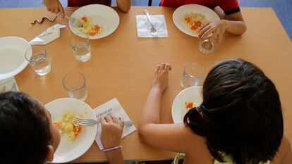 Alumnos y alumnas de un colegio en Fresnedillas de la Oliva, en la Comunidad de Madrid, comen en el comedor del colegio.