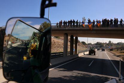 Un grupo de personas con 'esteladas' anima a los agricultores durante el corte de la autopista A-2, este miércoles cerca de Barcelona. 