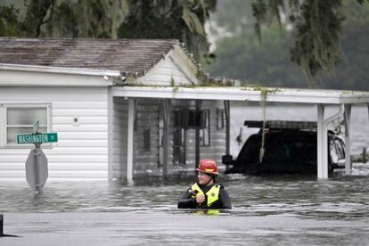 Una socorrista del Condado de Orange se abre paso entre el agua en busca de supervivientes, este jueves en Orlando.