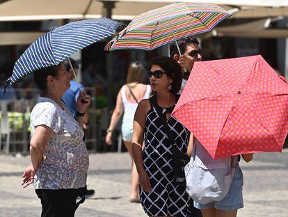 Varias personas pasean con una sombrilla por el centro de Madrid, el pasado día 26.