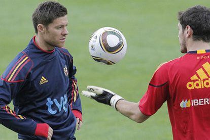 Casillas le muestra a Xabi Alonso el balón del Mundial, durante el entrenamiento del pasado viernes en Innsbruck.