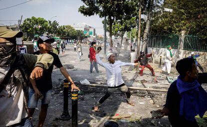 Los manifestantes han lanzado petardos y piedras a la Policía y han incendiado una de las calles cercanas a la agencia de supervisión electoral en su intento de romper la barrera de seguridad. En la imagen, los seguidores del candidato opositor se enfrentan a los agentes de la policía antidisturbios durante una protesta frente al edificio de la Junta de Supervisión de Elecciones (Bawaslu), en Yakarta.