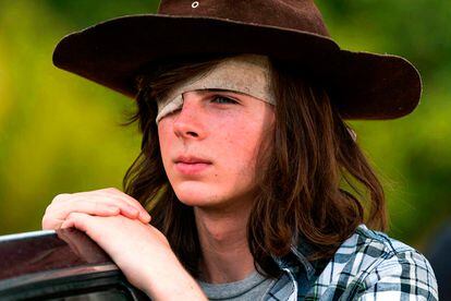 CHANDLER RIGGS (CARL) ¿Los estudios? No.
En la misma semana en la que se ha estrenado la segunda mitad de la novena temporada, el padre de Chandler Riggs no ha aguantado más y ha revelado que a su hijo le obligaron a dejar la serie, y que dicha decisión le dejó “devastado”. Recordemos que Carl Grimes, el hijo tuerto del líder de los supervivientes, era mordido por un Caminante en la octava temporada (febrero de 2018). El chaval, confirmaron, quería dejar la interpretación para centrarse en su carrera universitaria.
En un comentario en Facebook –que luego borró– William Riggs ha desmontado esta versión. Ha afirmado que en abril Scott Gimble le aseguró su permanencia por tres años más –llegando al acuerdo de continuar en principio por dos entregas–, pero que en junio, tras rodar los cinco primeros episodios, el showrunner los había convocado a una “extraña” reunión en la que descubrieron por sorpresa que eliminaban al crío. En ningún caso, zanja el airado progenitor, la universidad era un problema pues su hijo llevaba ocho años compaginando el trabajo con los estudios. El debut inminente de Chandler Riggs en la nueva serie A Millon Little Things y el estreno de un par de películas vendrían a confirmar sus palabras, que lo que se dice dejar los platós no era su intención. La única justificación lógica podría estar en el salto en el tiempo de seis años de esta temporada: inviable para la transformación física del actor y coartada perfecta para dar mayor protagonismo a Judith Grimes, una réplica en miniatura, con sombrero incluido, del propio Carl.