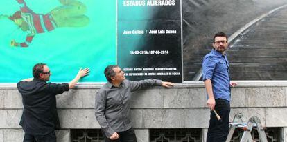 Los artistas y el comisario de la exposición 'Estados alterados' colocan el cartel en el exterior de las Juntas Generales. 