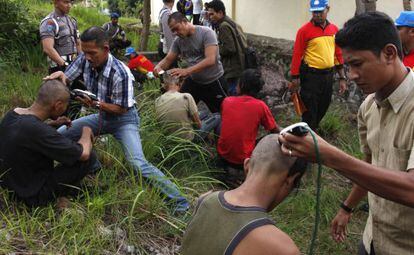 Policías de paisano afeitan a los jóvenes punk detenidos en Indonesia.
