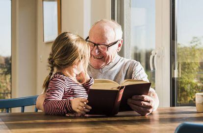 Un abuelo disfruta leyendo con su nieta.