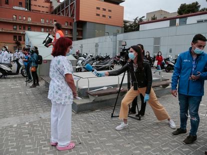 Una periodista de televisión entrevista a profesionales sanitarios frente al Hospital Vall d'Hebron el pasado 12 de mayo.