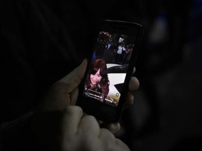 Una persona mira el video del intento de magnicidio contra Cristina Fernández de Kirchner en su móvil, afuera de la residencia de la vicepresidenta, este jueves.