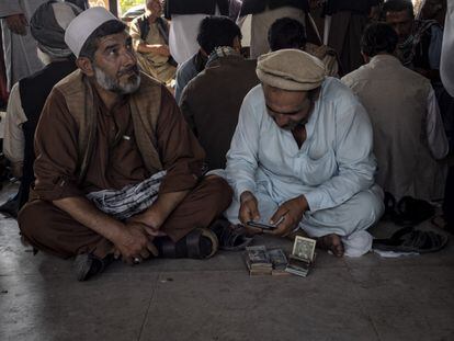 Un hombre cuentan fajos de billetes en el mercado de cambio de Sarai Shahzada.
