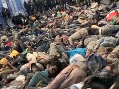SENSITIVE MATERIAL. THIS IMAGE MAY OFFEND OR DISTURB    A view shows a large number of African migrants lying closely piled together, with Moroccan security forces standing over them in riot gear, at the Barrio Chino Border Checkpoint, Morocco, in this undated screen grab taken from a social media video obtained by Reuters on June 25, 2022. AMDH/via REUTERS  THIS IMAGE HAS BEEN SUPPLIED BY A THIRD PARTY. MANDATORY CREDIT. NO RESALES. NO ARCHIVES.