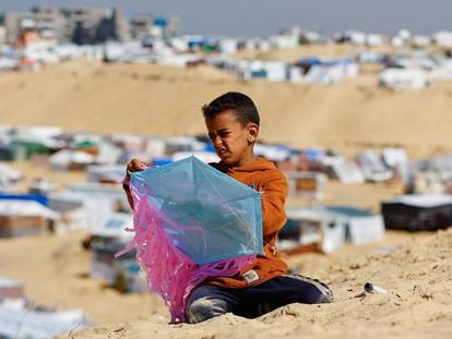 Un niño prepara una cometa frente a las tiendas de campaña de familias gazatíes desplazadas por la guerra en Rafah (Gaza), junto a la frontera con Egipto, el 8 de febrero.