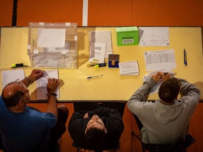Los componentes de una mesa electoral esperan a que los ciudadanos voten en la Escola Grèvol (Barcelona).
