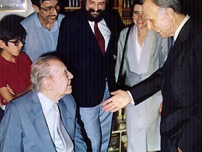 Borges, sentado, conversa con Bioy Casares.