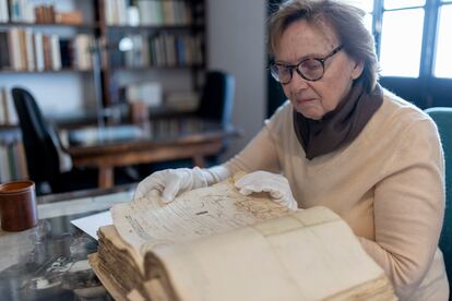 Liliane Dahlmann hojea un volumen del archivo.